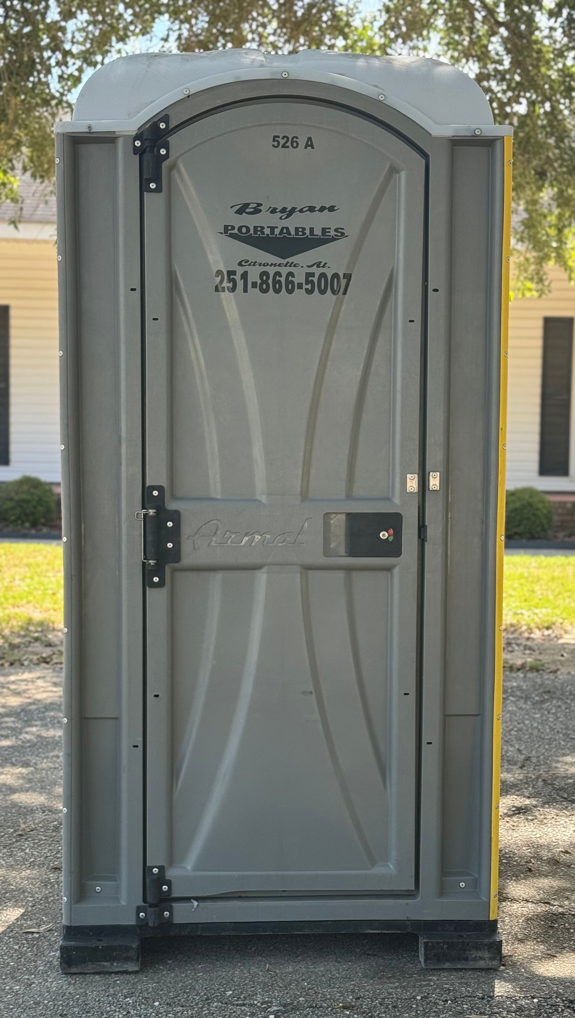 A portable toilet is sitting in front of a house.
