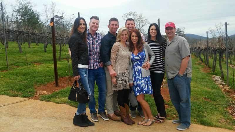 group of people posing in grape vineyard