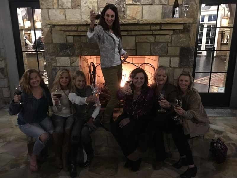 woman holding drink up with group of people