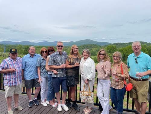 group of people in front of a vinyard