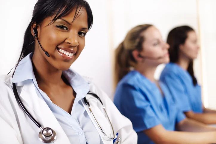A female doctor wearing a headset smiles for the camera