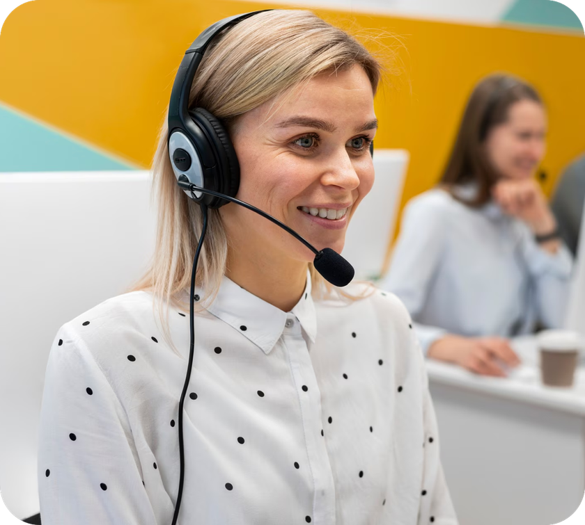 A woman wearing a headset is smiling in a call center.