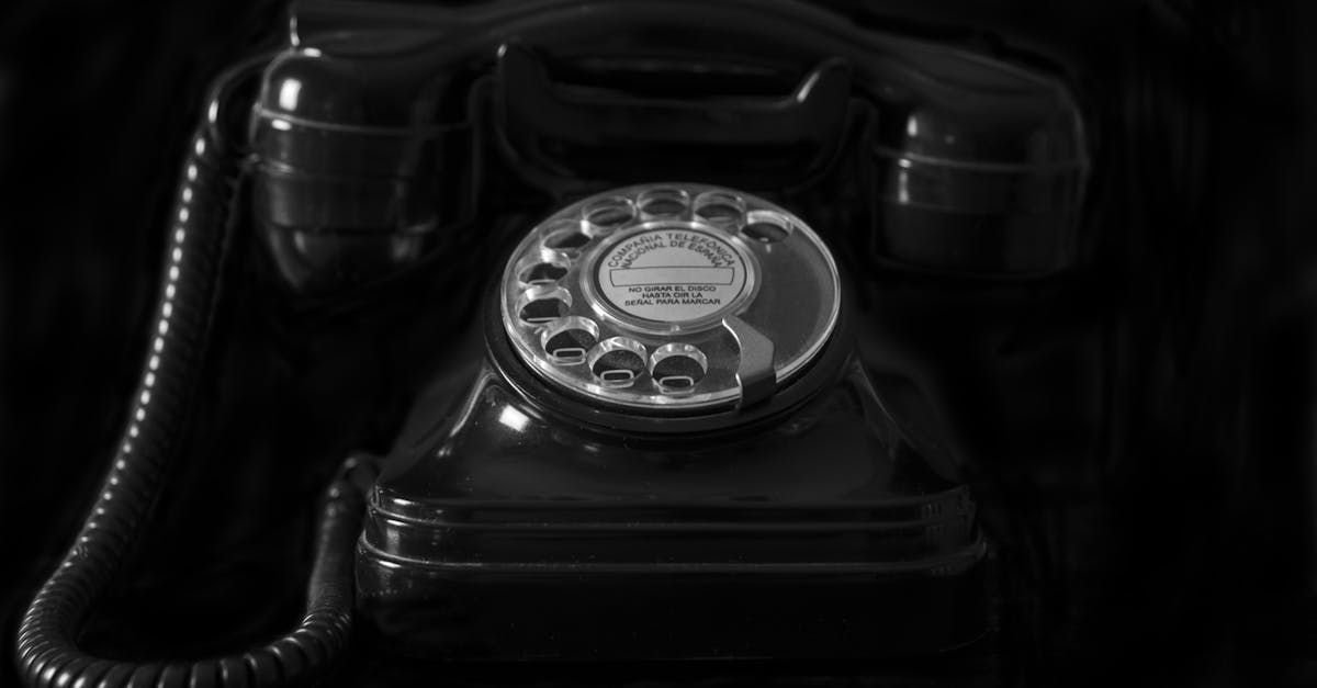 A black and white photo of an old telephone on a table.