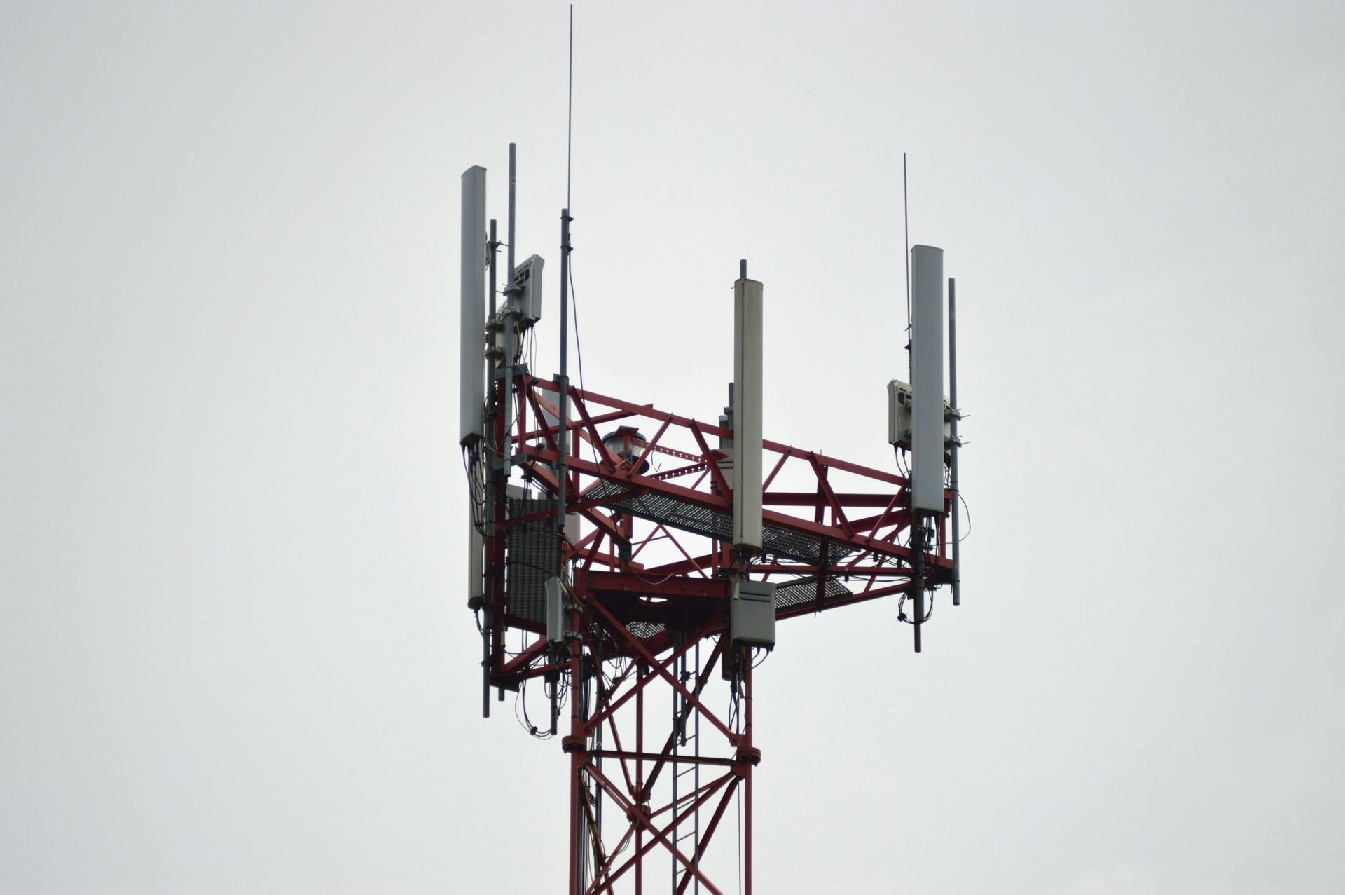 A red and white tower with a lot of antennas on it