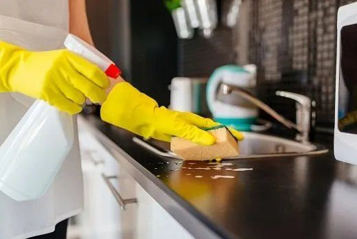Professional cleaner doing a thorough clean of the kitchen of a residential home in Mackay, QLD.