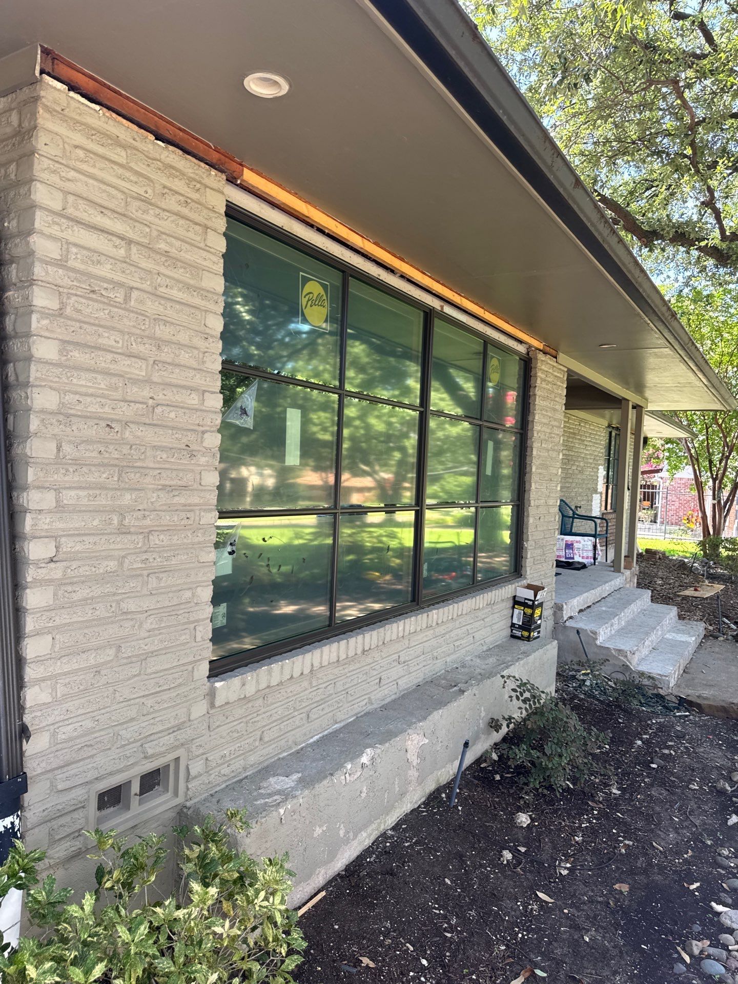 Two electricians working on an electrical panel outside a building. One holds a cable.