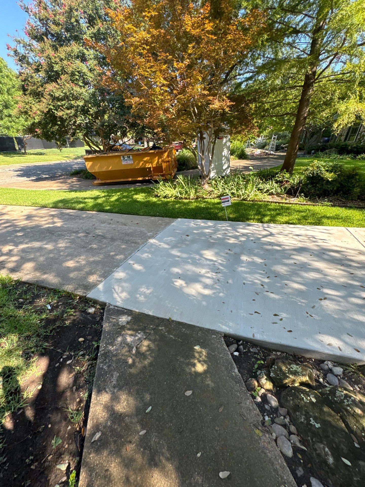 Two electricians working on an electrical panel outside a building. One holds a cable.