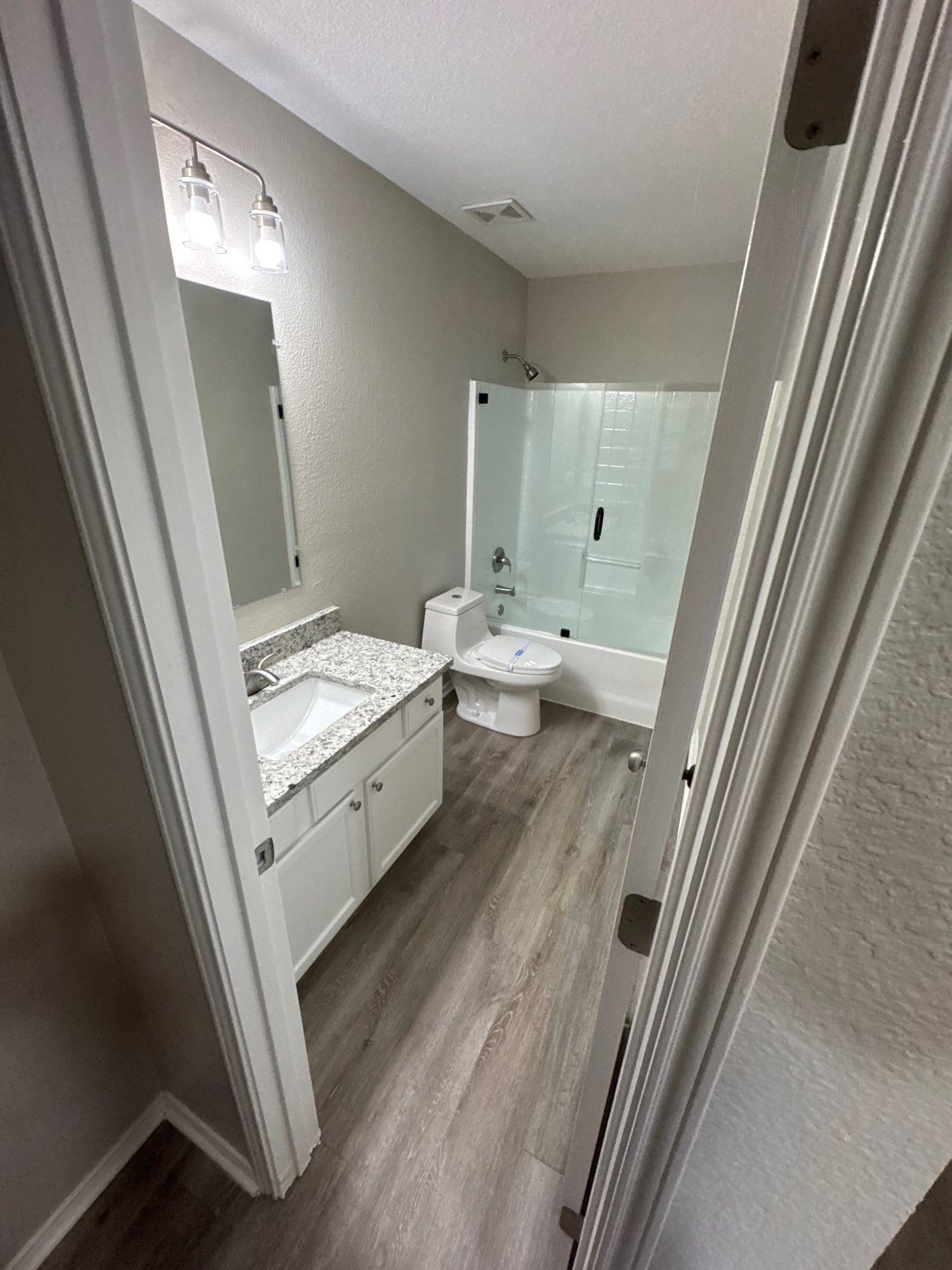Two electricians working on an electrical panel outside a building. One holds a cable.