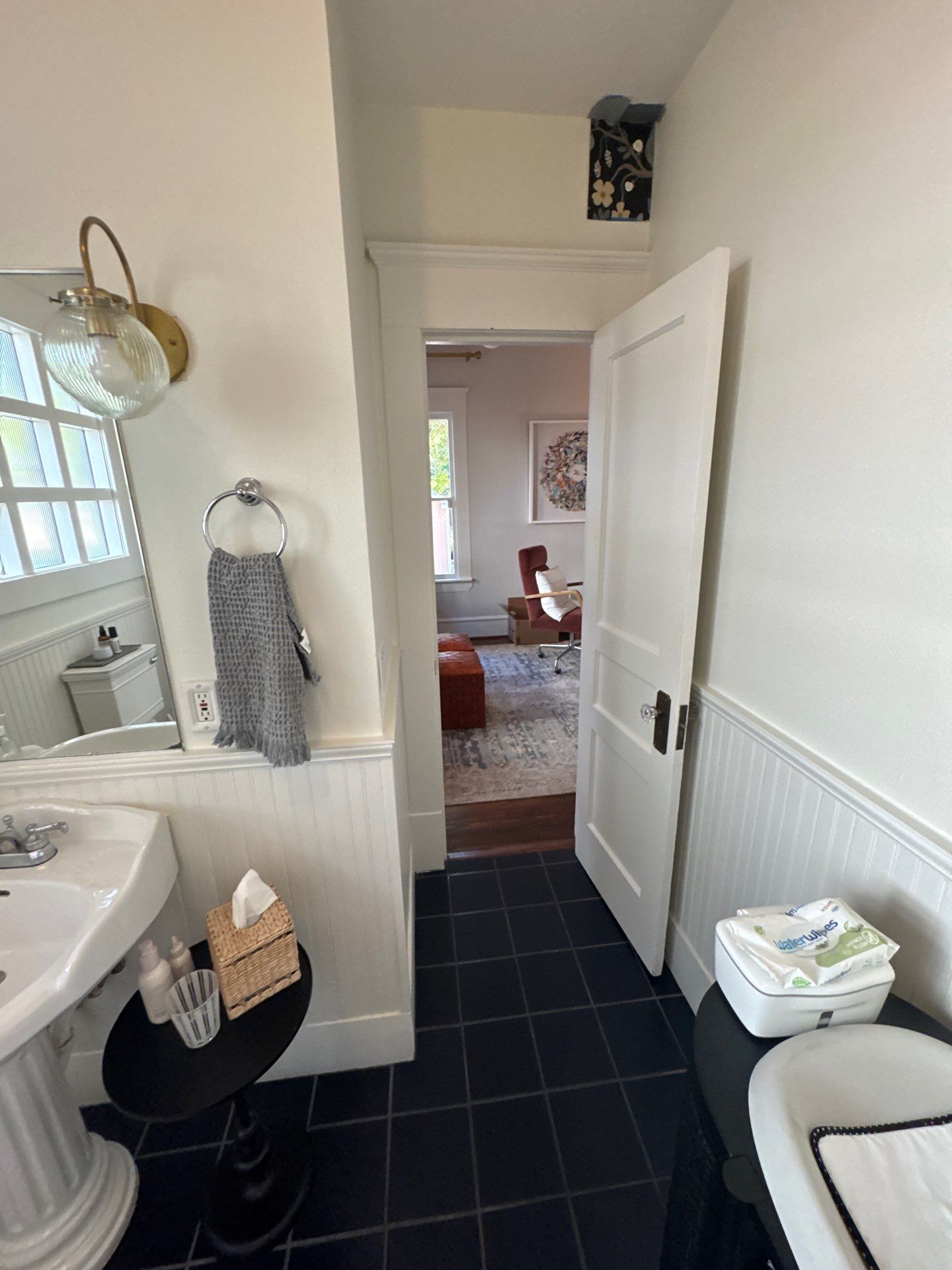 A person digs a trench in a backyard near a small excavator, a tree, and a house.