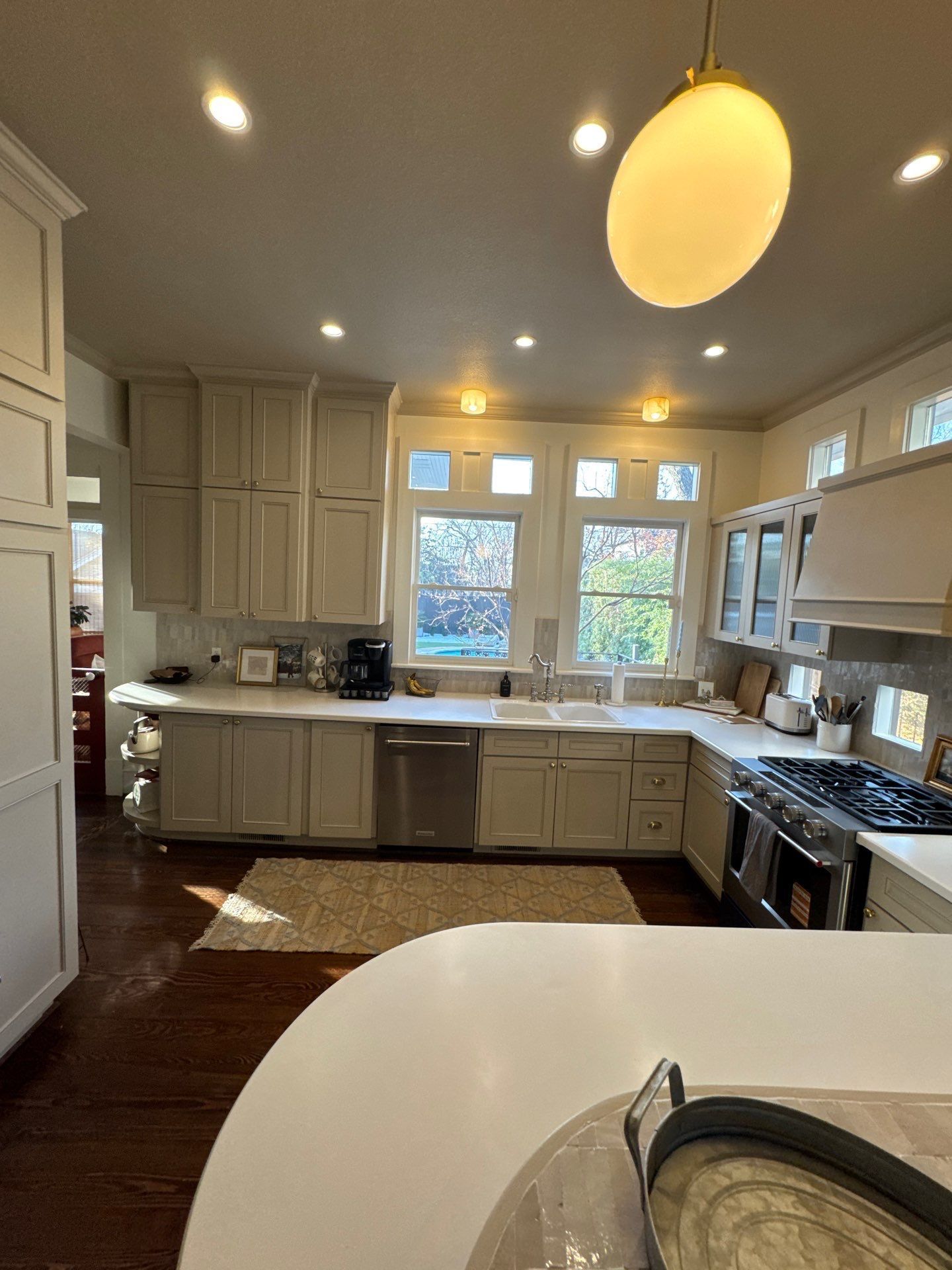 Trench dug in a grassy yard, leading to a house with black siding, and an electrical box.