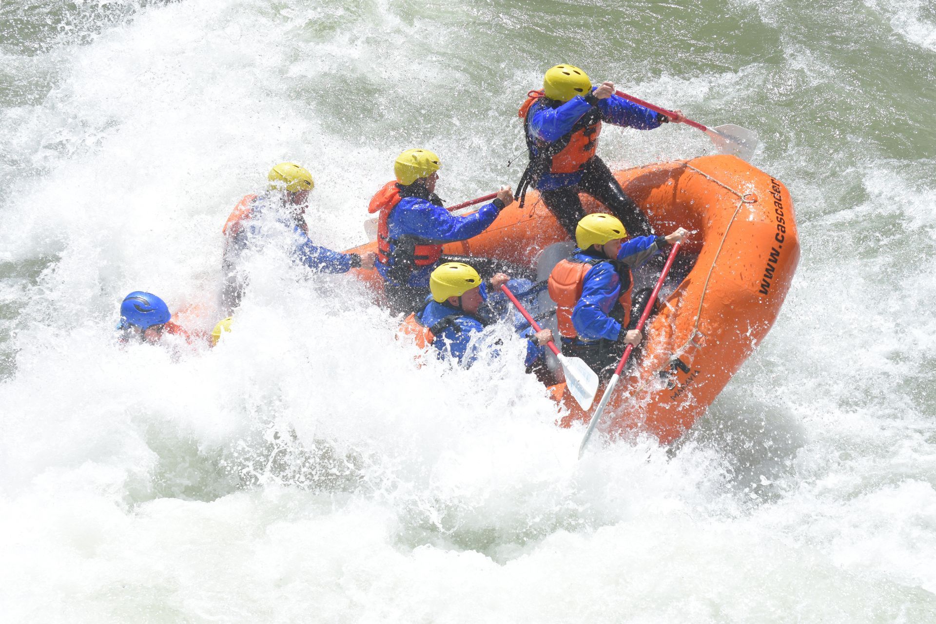 Whitewater raft mostly underwater in big rapids