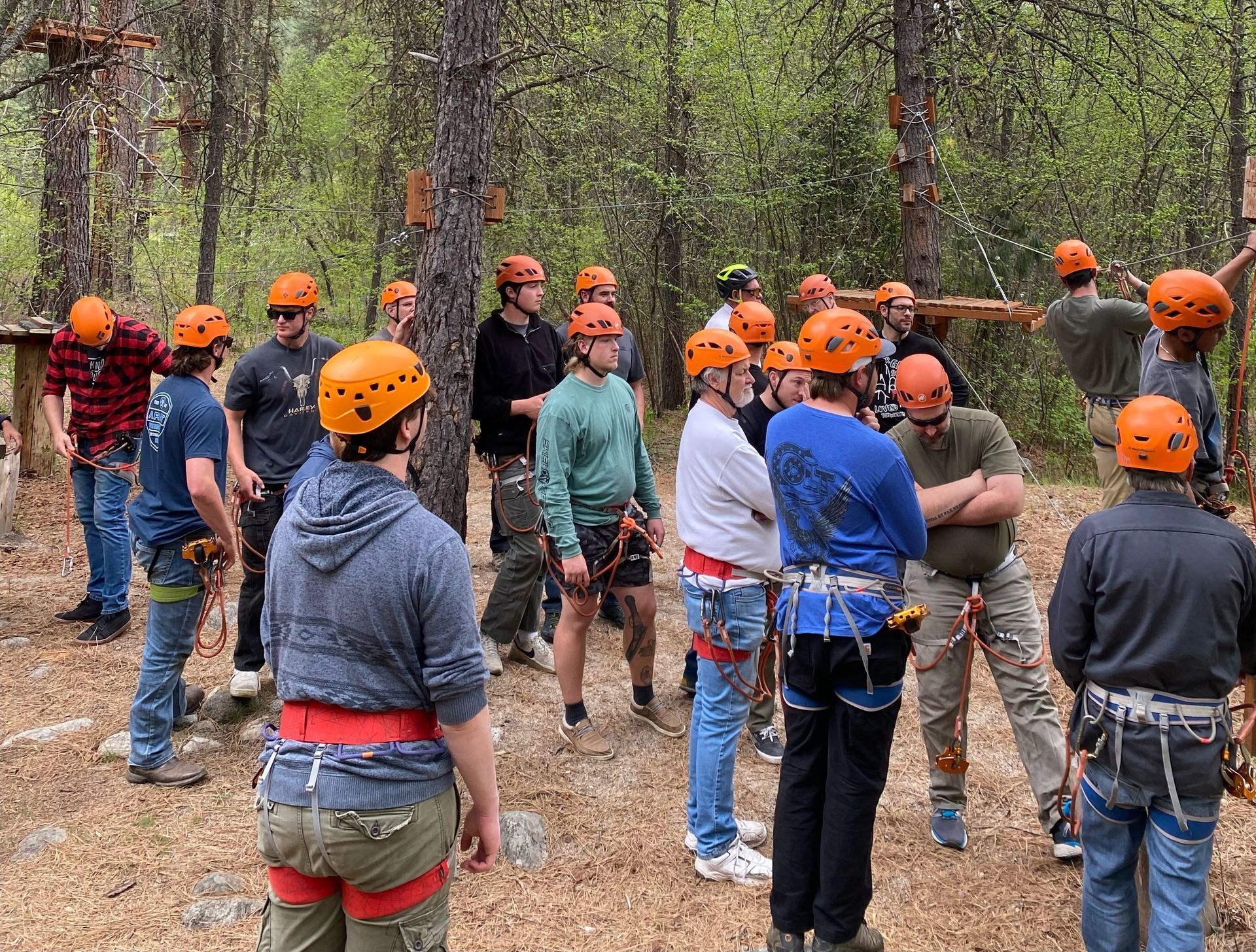 Group of people learning how to use zipline course safely.