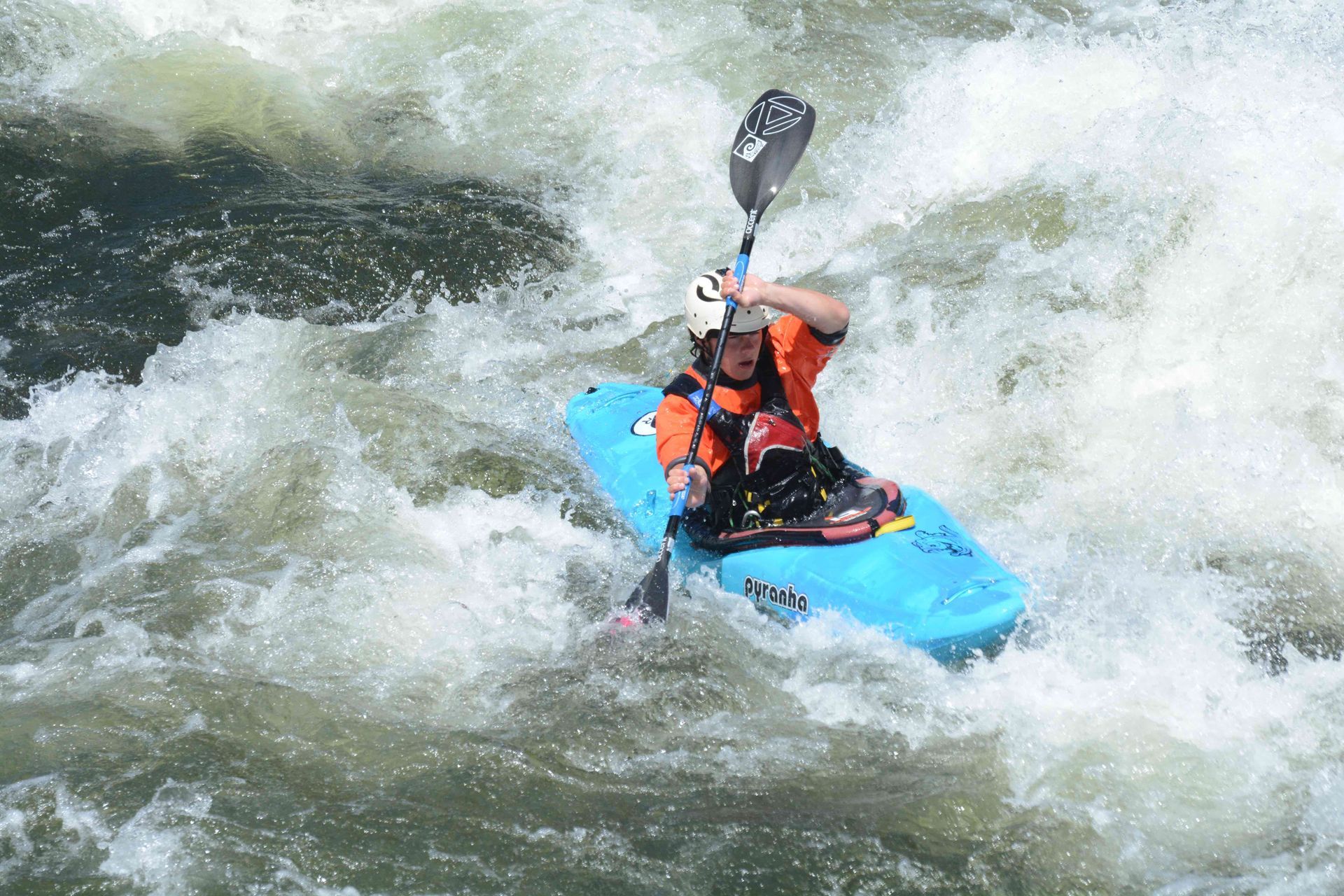 Whitewater kayaker in blue kayak on Payette River