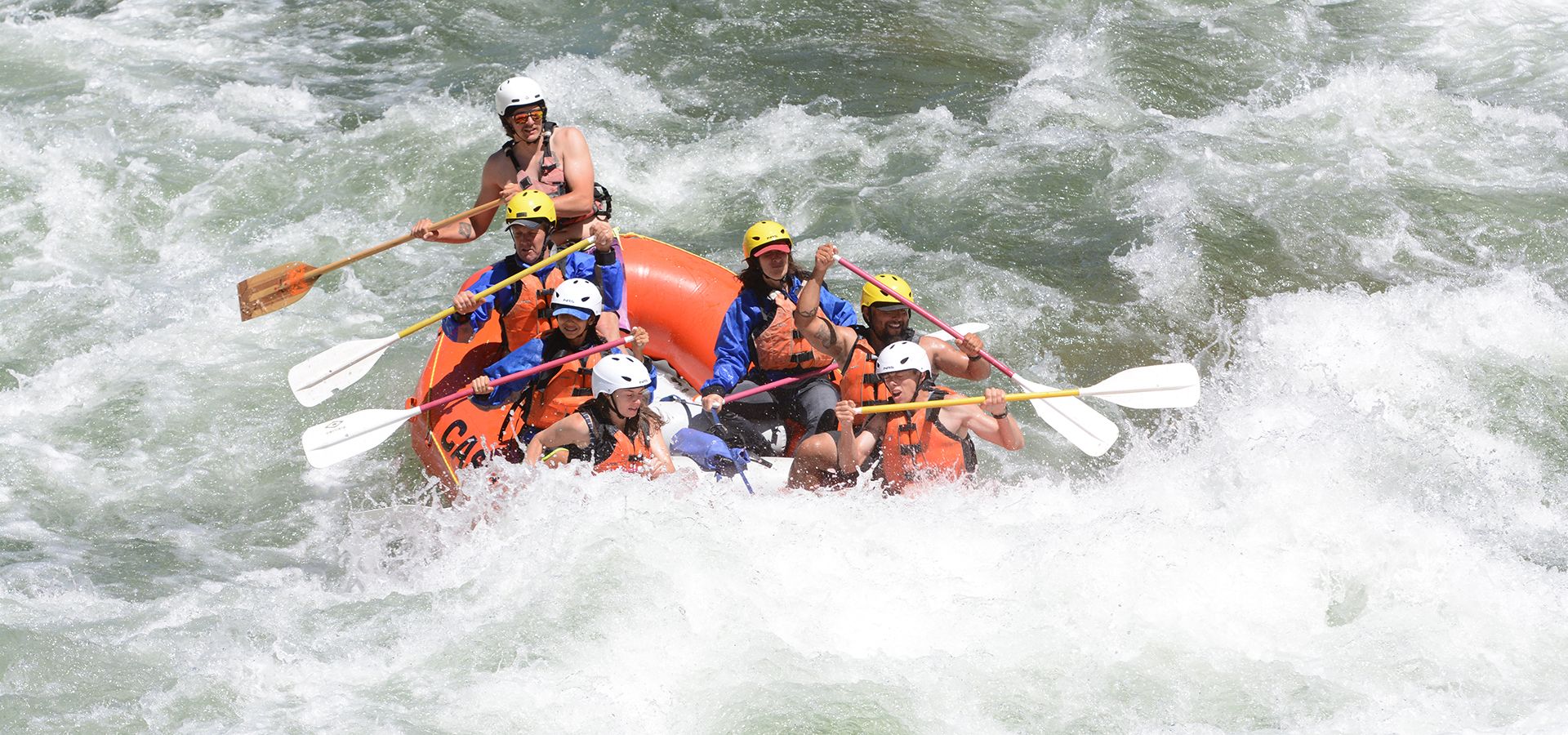 group paddling in whitewater raft
