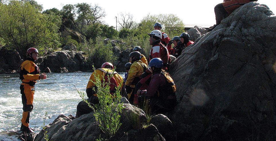 Many people near river learning swiftwater rescue