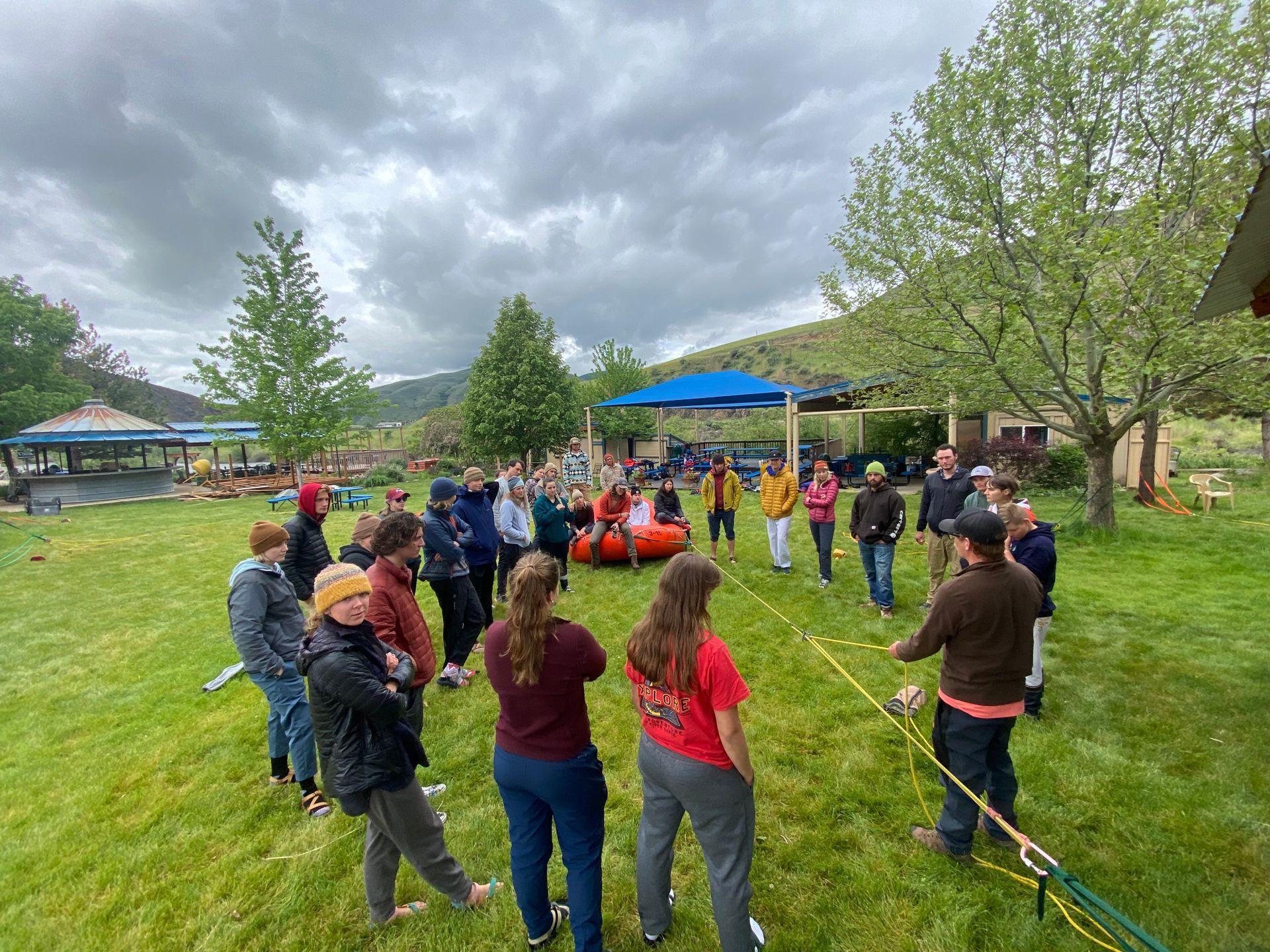 Group on grass near river with ropes for rescue