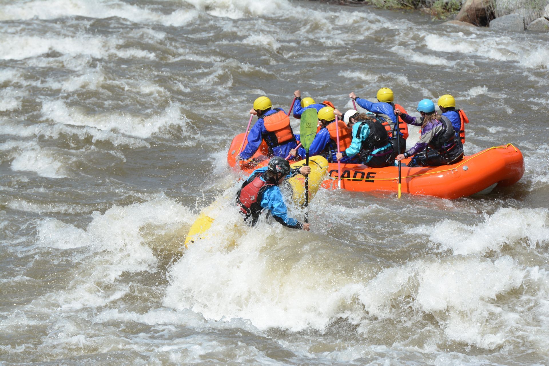 kayaker and raft in whitewater rapid