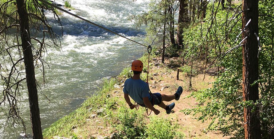 Person going on zipline near river in Boise National Forest