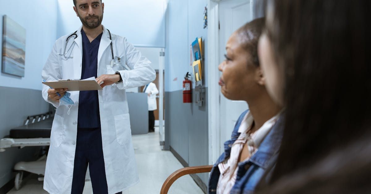 A doctor is talking to a patient in a hospital hallway.