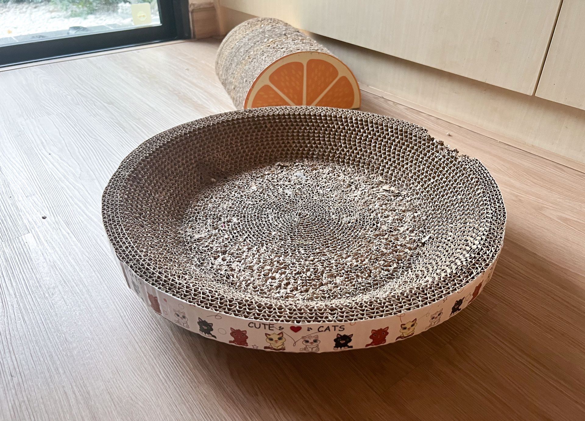 Round Cat Scratcher made of corrugated paper placed on the floor in the living room
