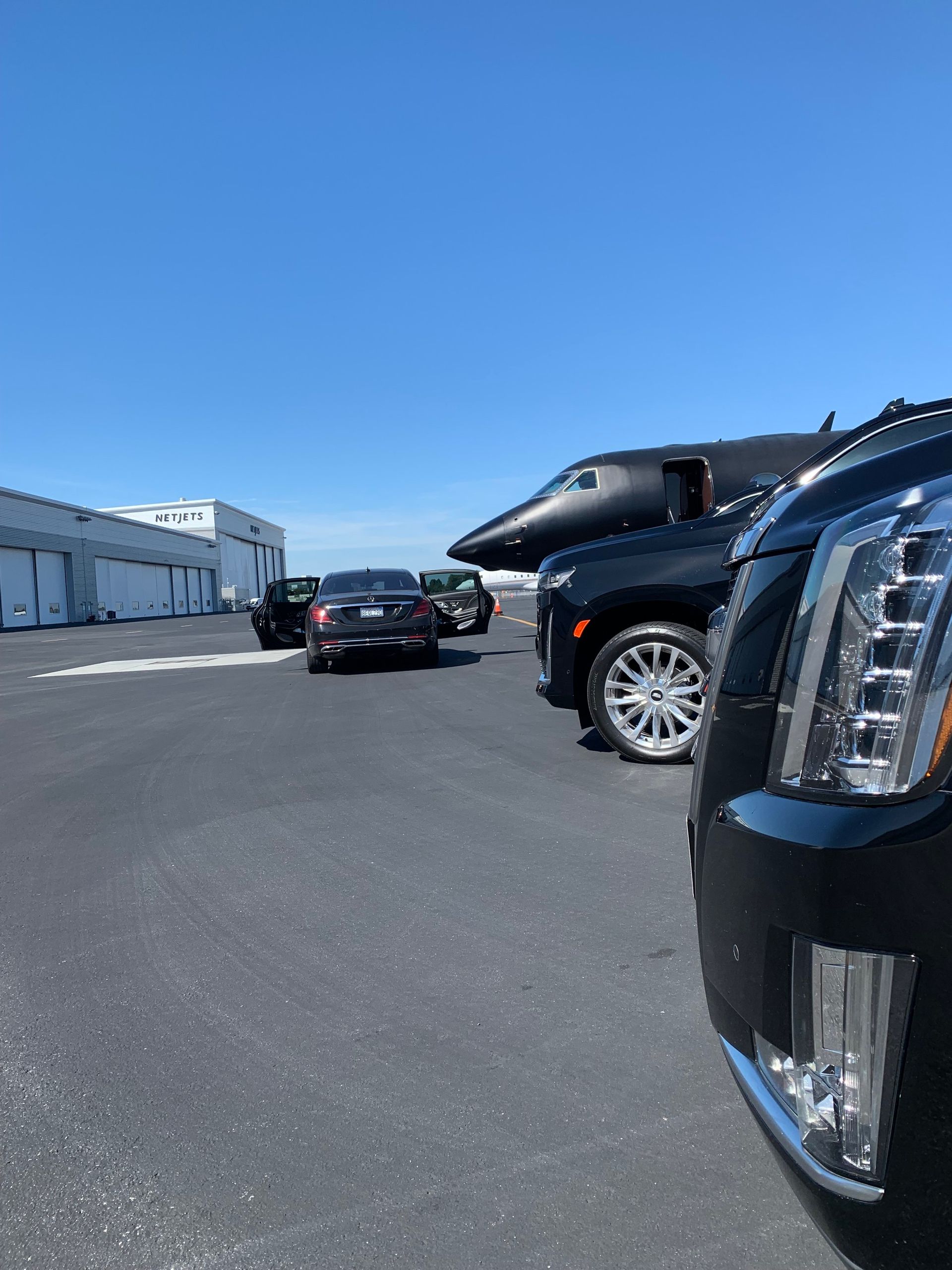 A row of cars are parked in a parking lot