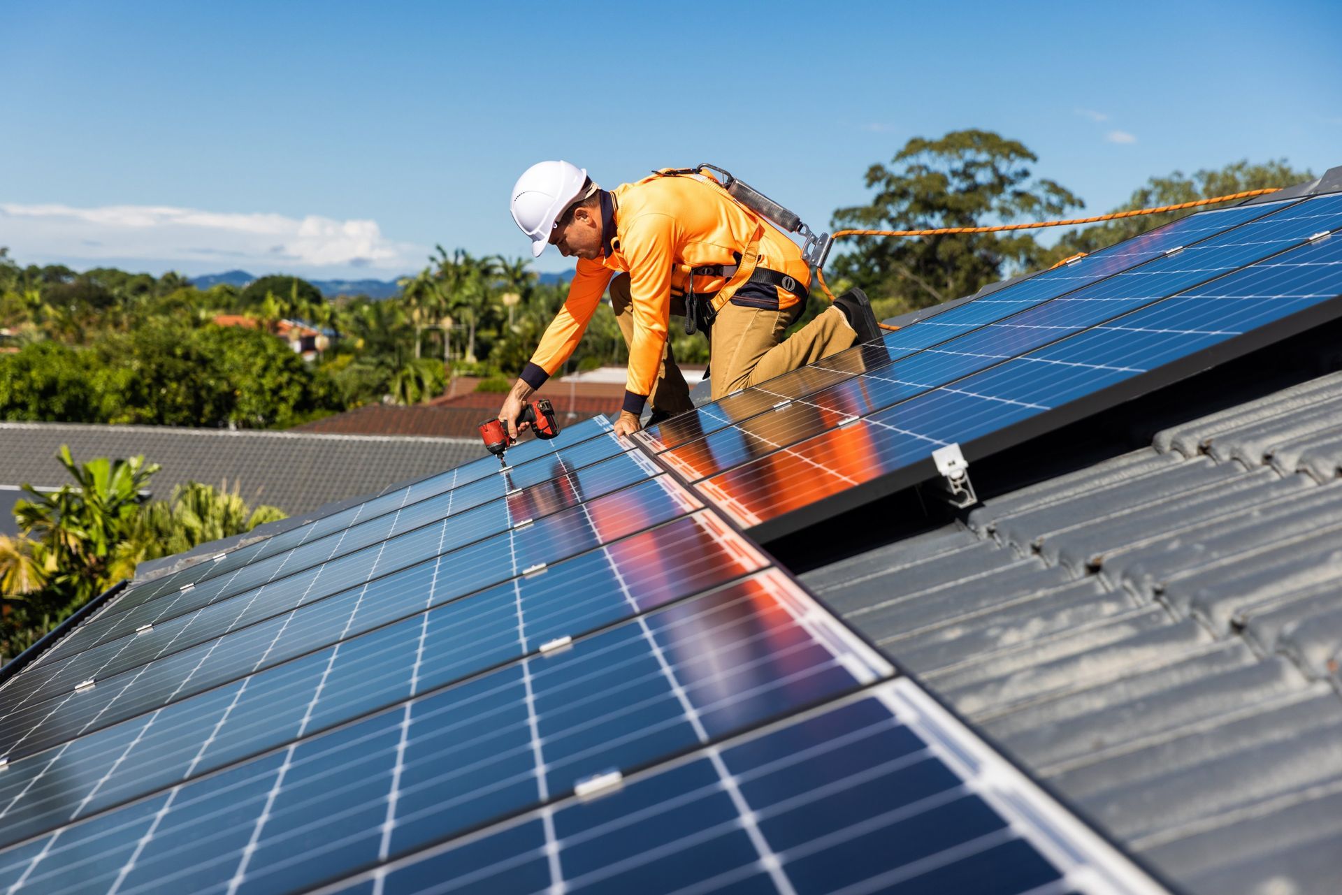 Solar panel installer on rooftop, installing photovoltaic panels on a sunny day.
