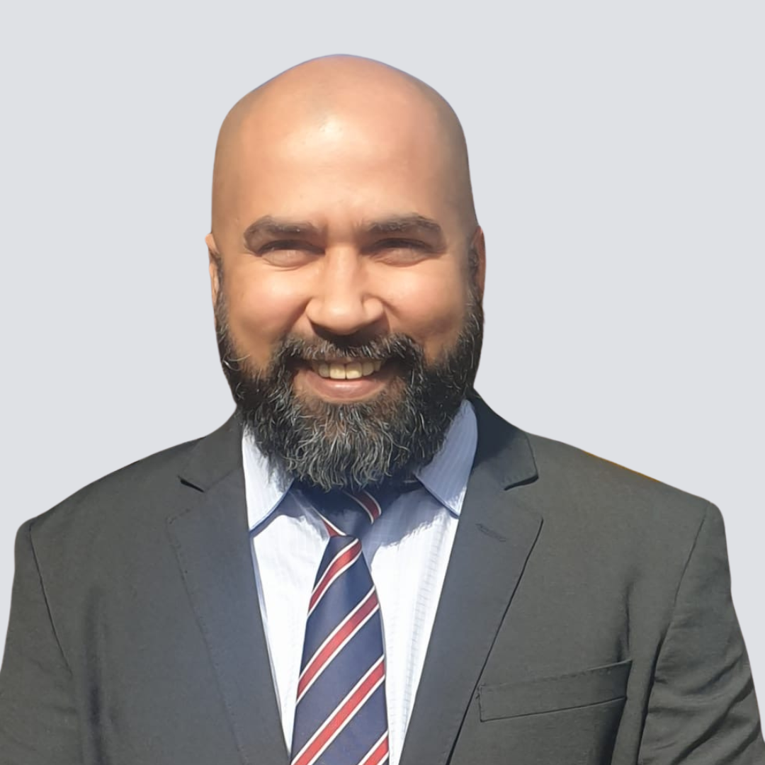 A bald man with a beard wearing a suit and tie