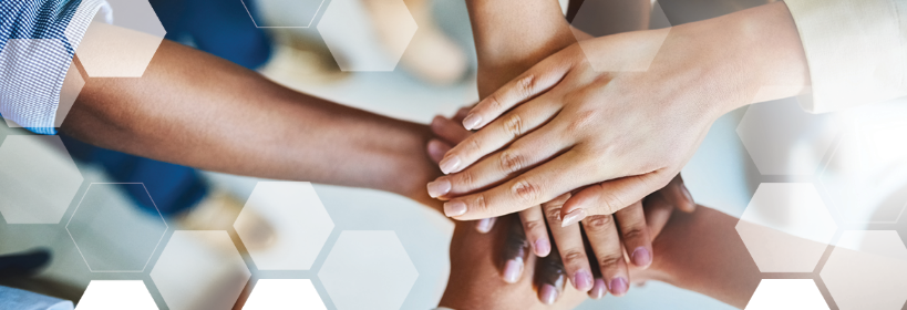 A group of people are putting their hands together.