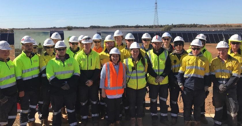 A group of construction workers are posing for a picture.