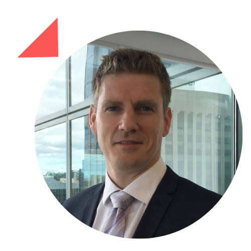 A man in a suit and tie is standing in front of a window