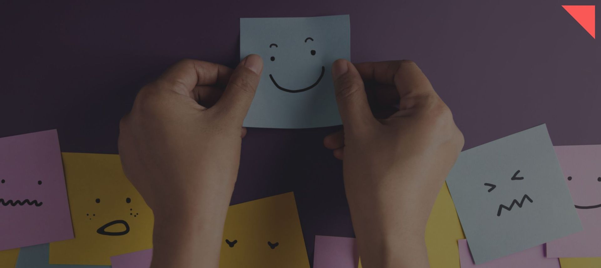 Post note with smily face surrounded by other different faced post notes.