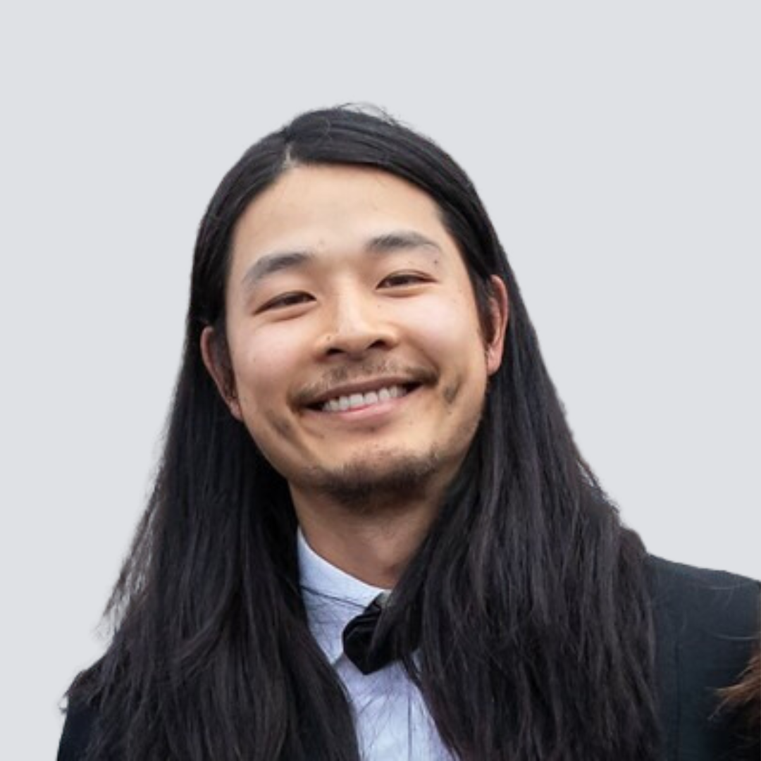 A man with long hair and a beard is smiling for the camera