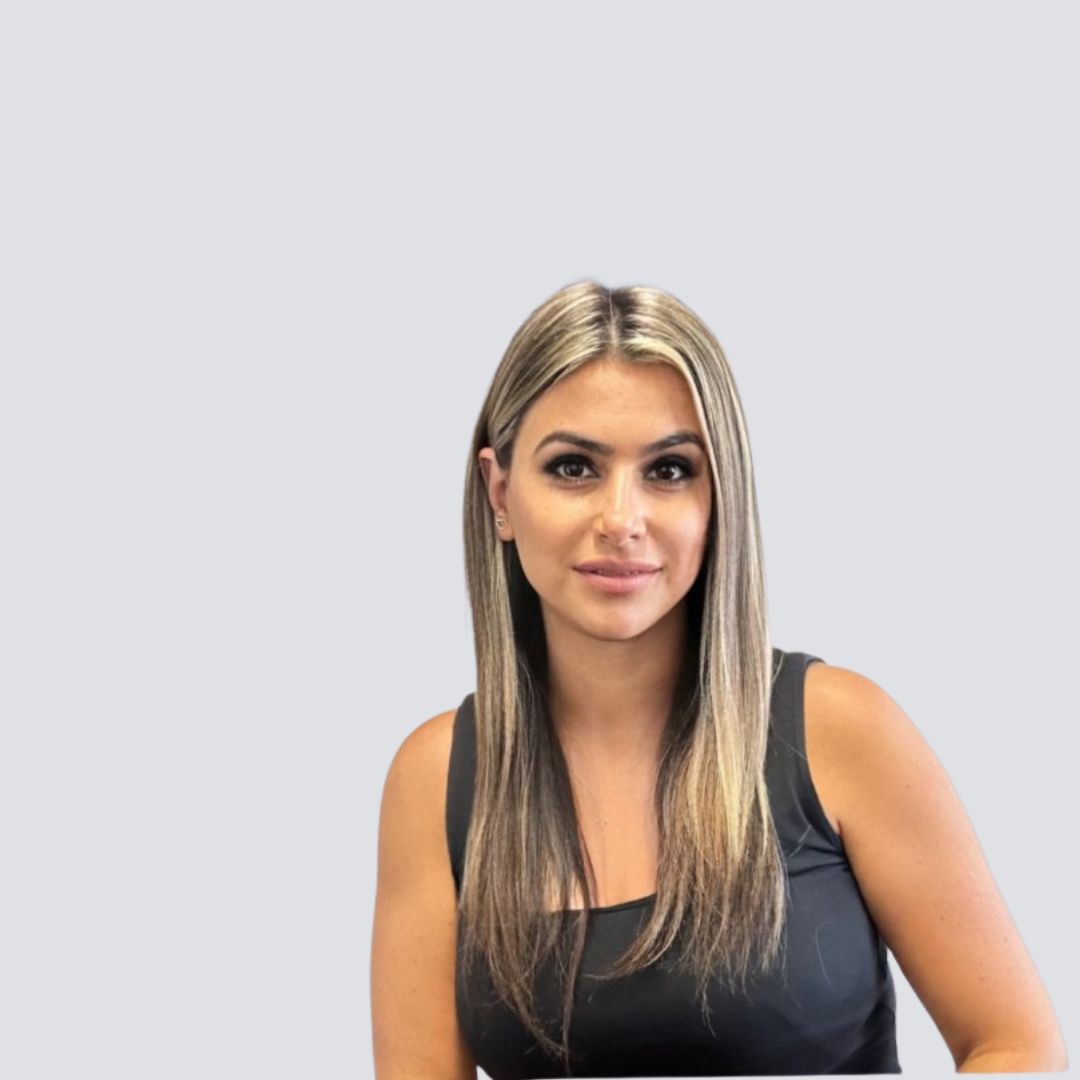 A woman with long blonde hair is wearing a black tank top