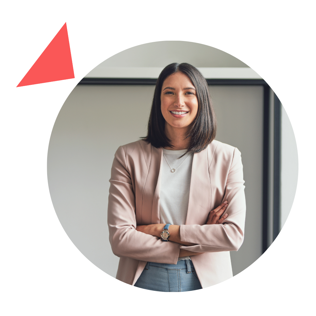 A woman in a pink jacket is standing in a circle with her arms crossed and smiling.