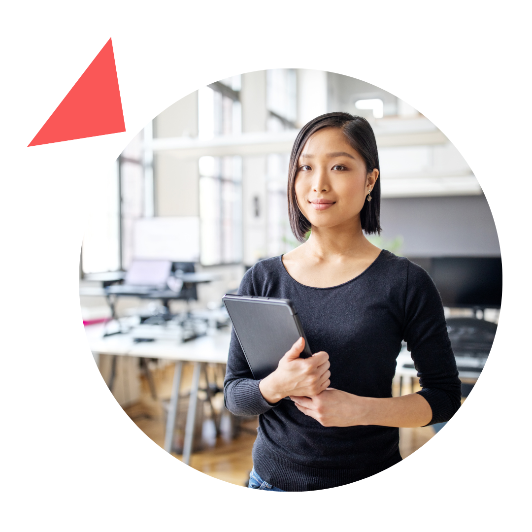 A woman in a black shirt is holding a tablet in an office.