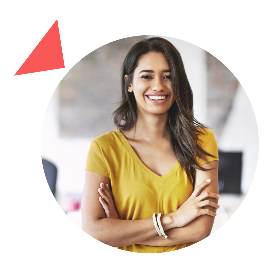A woman in a yellow shirt is smiling with her arms crossed.