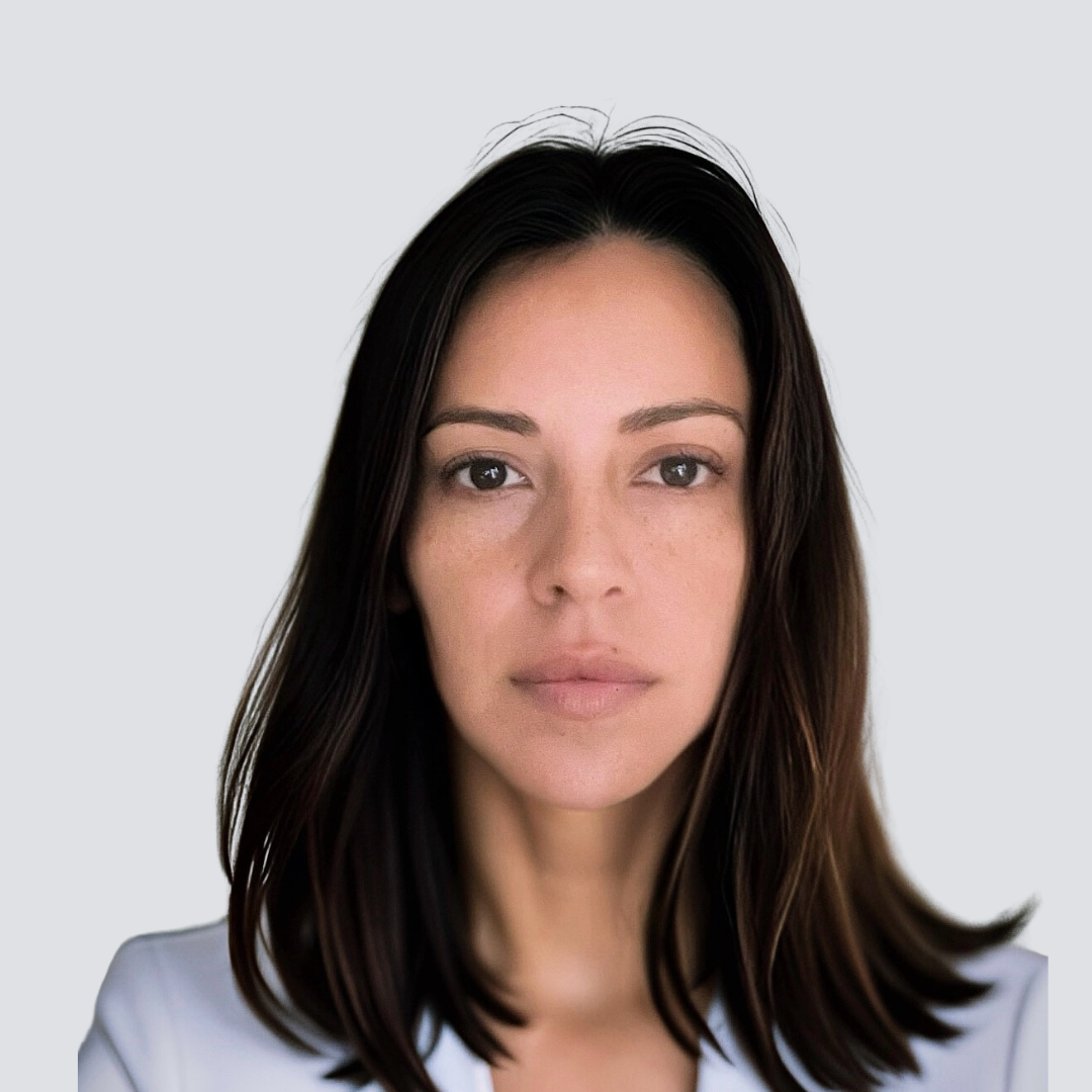 A woman with long dark hair is wearing a white jacket