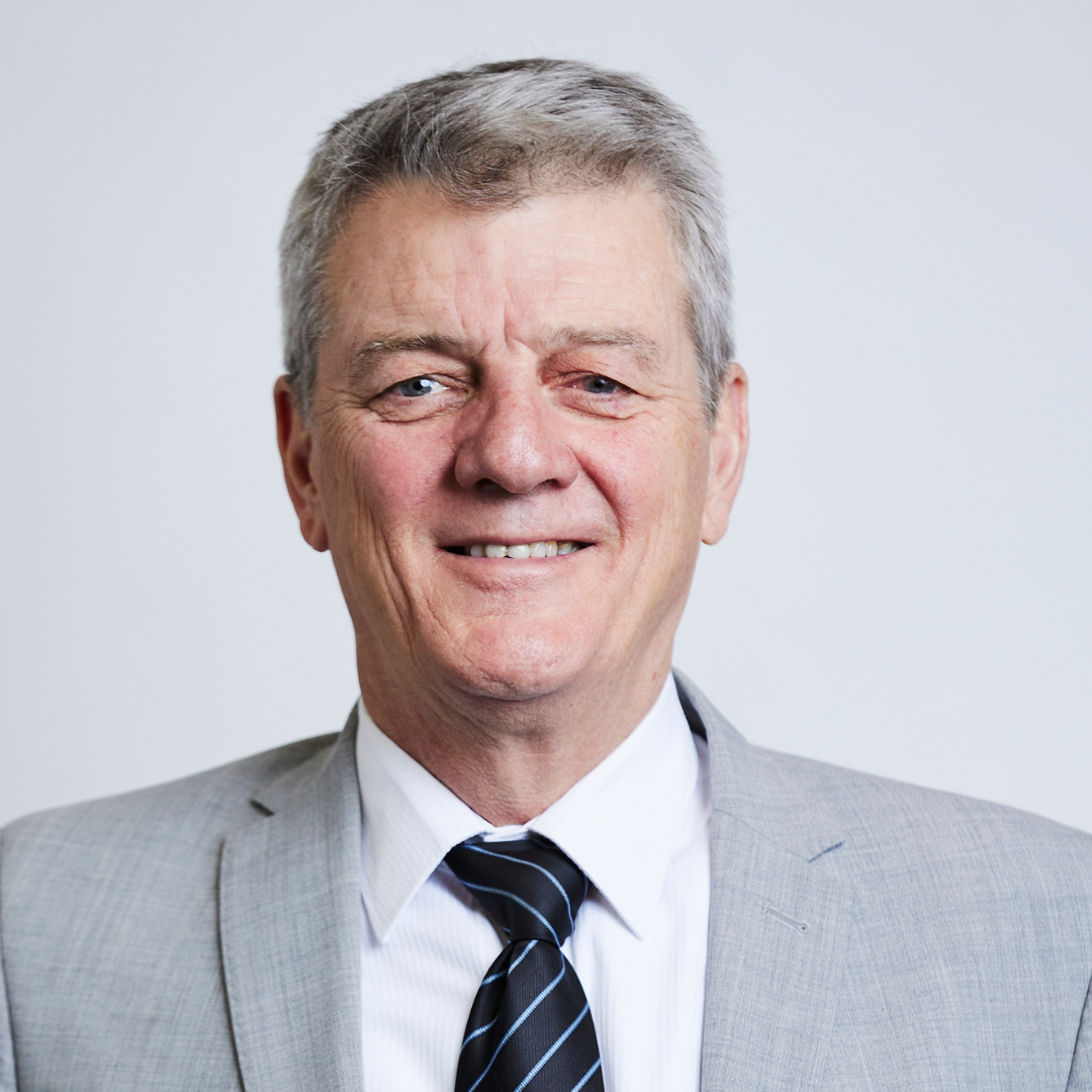 A man in a suit and tie is smiling for the camera