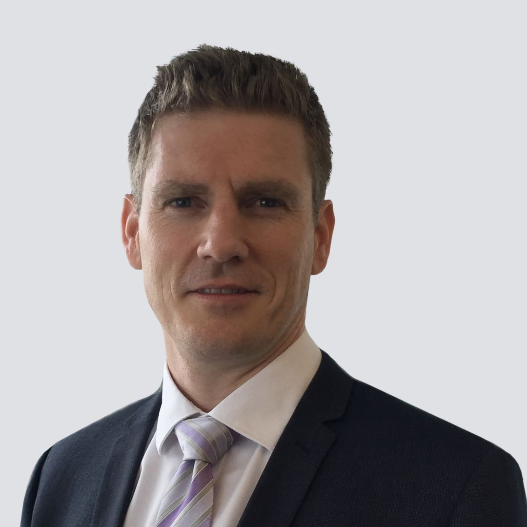 A man in a suit and tie is smiling for the camera