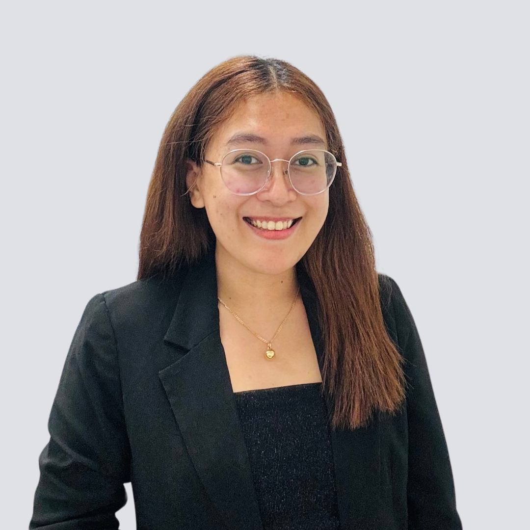 A woman wearing glasses and a black jacket is smiling for the camera.