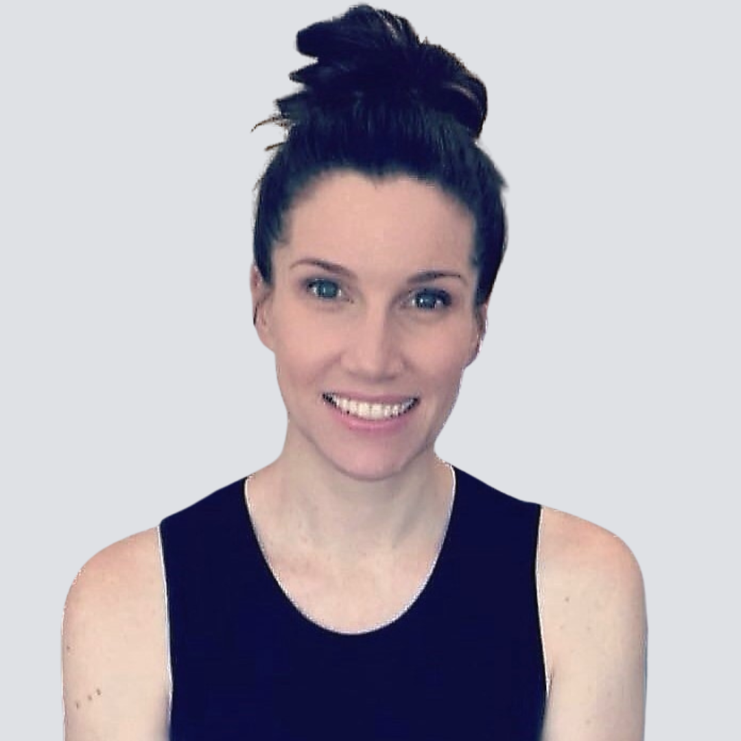 A woman with her hair in a bun is smiling and wearing a black tank top
