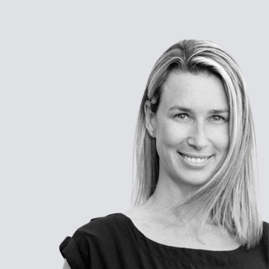 A woman in a black dress is smiling in a black and white photo.