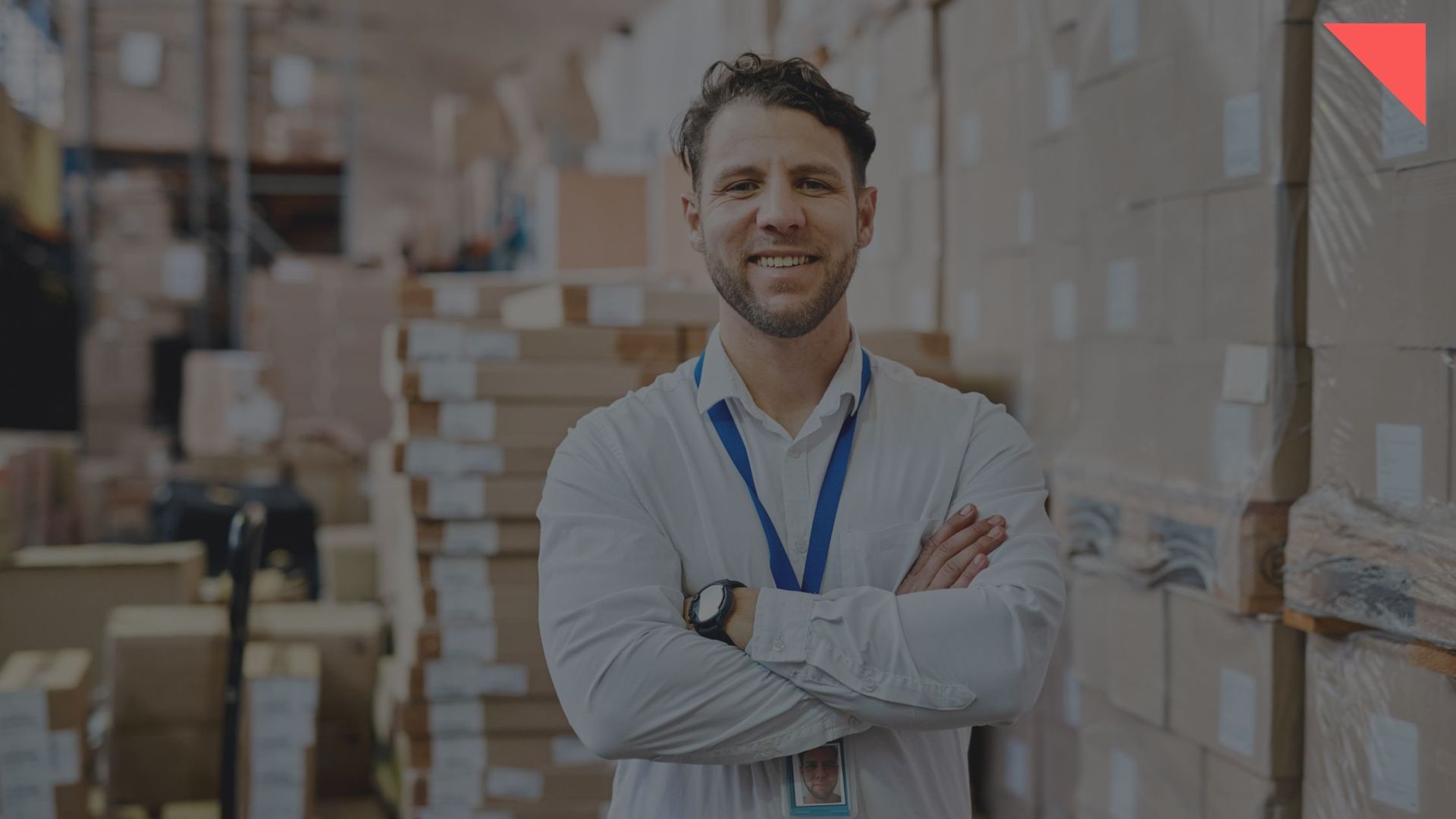 business leader standing with white shirt arms folded in warehouse environment