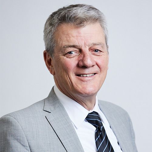 A man in a suit and tie is smiling for the camera.