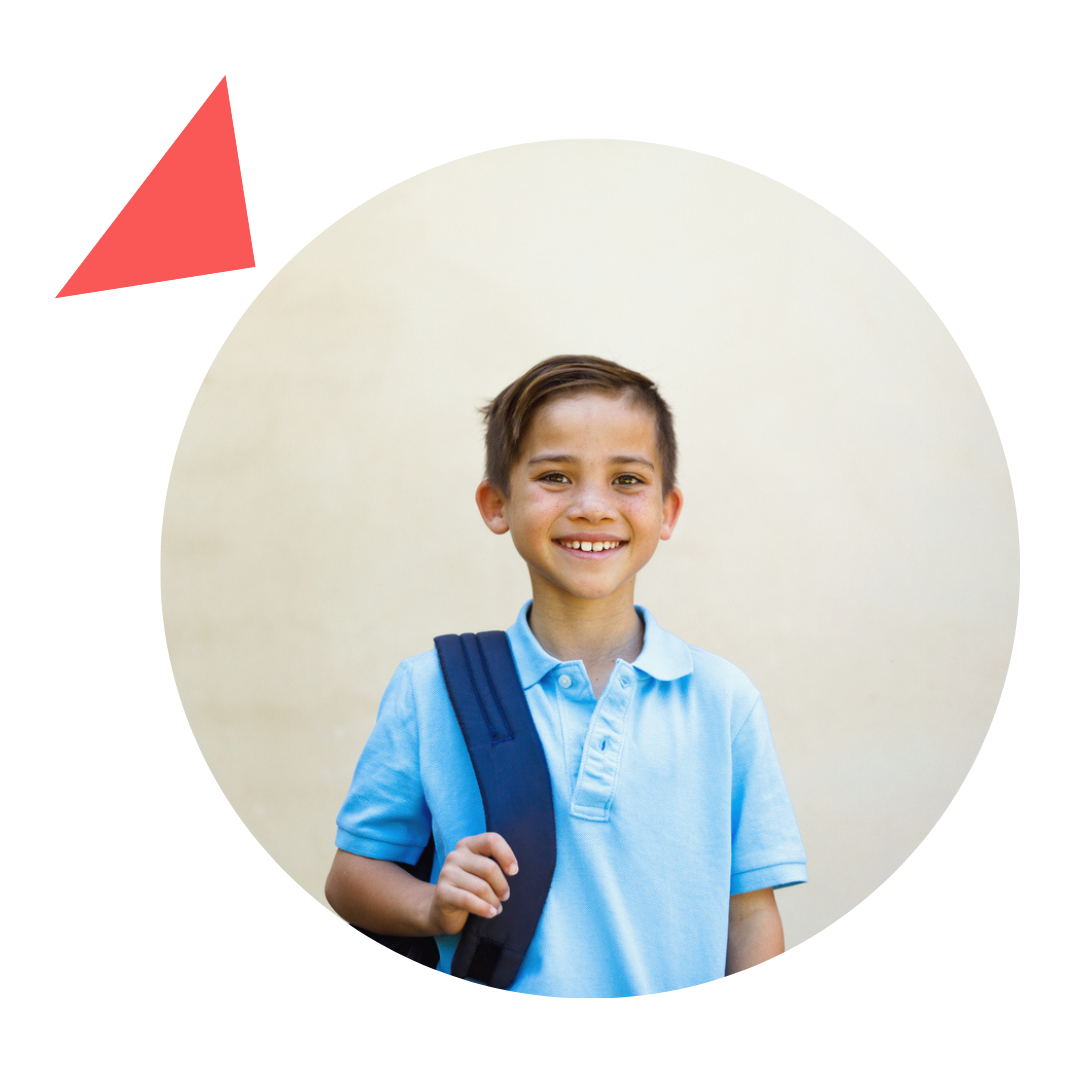 A young boy in a blue shirt is carrying a backpack.