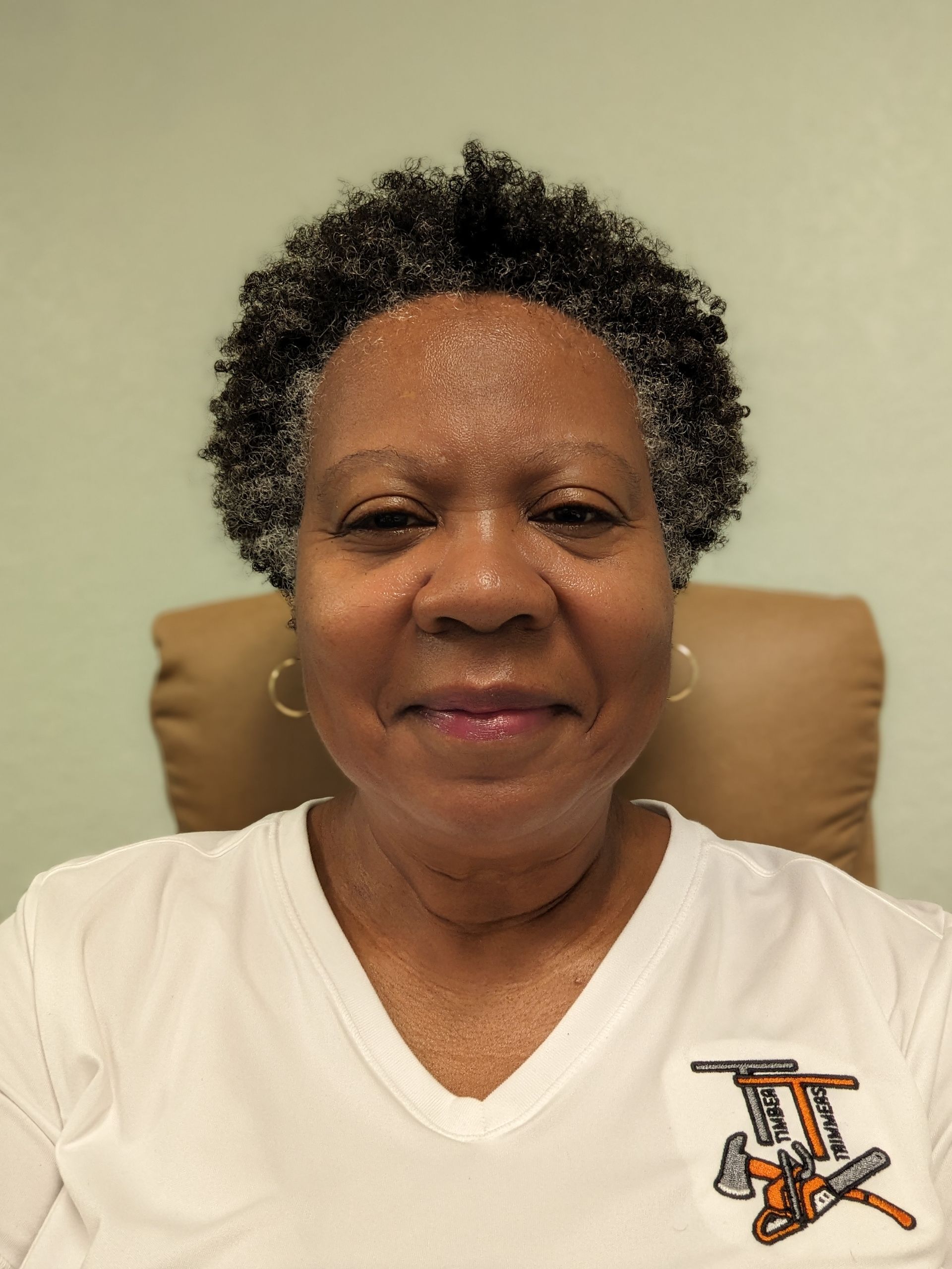 A woman wearing a white shirt with tools on it