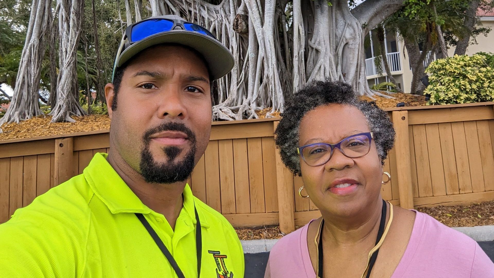 A man and a woman are posing for a picture in front of a tree.
