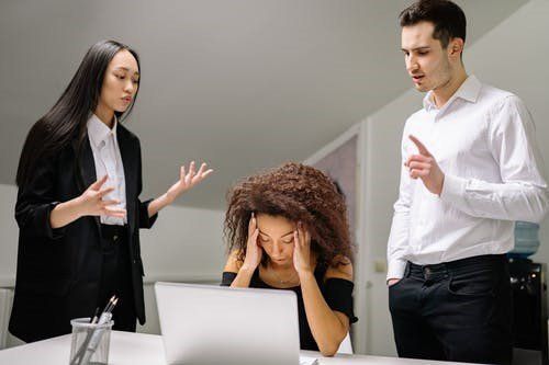 A woman facing workplace harassment by two employees