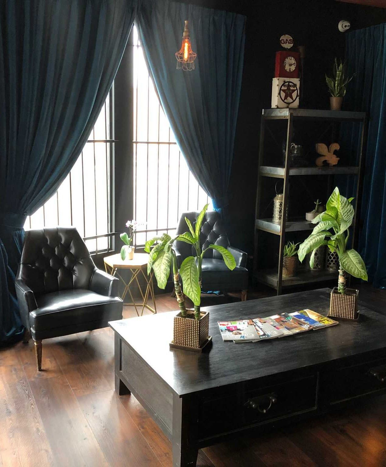 A living room with a table , chairs , and plants.