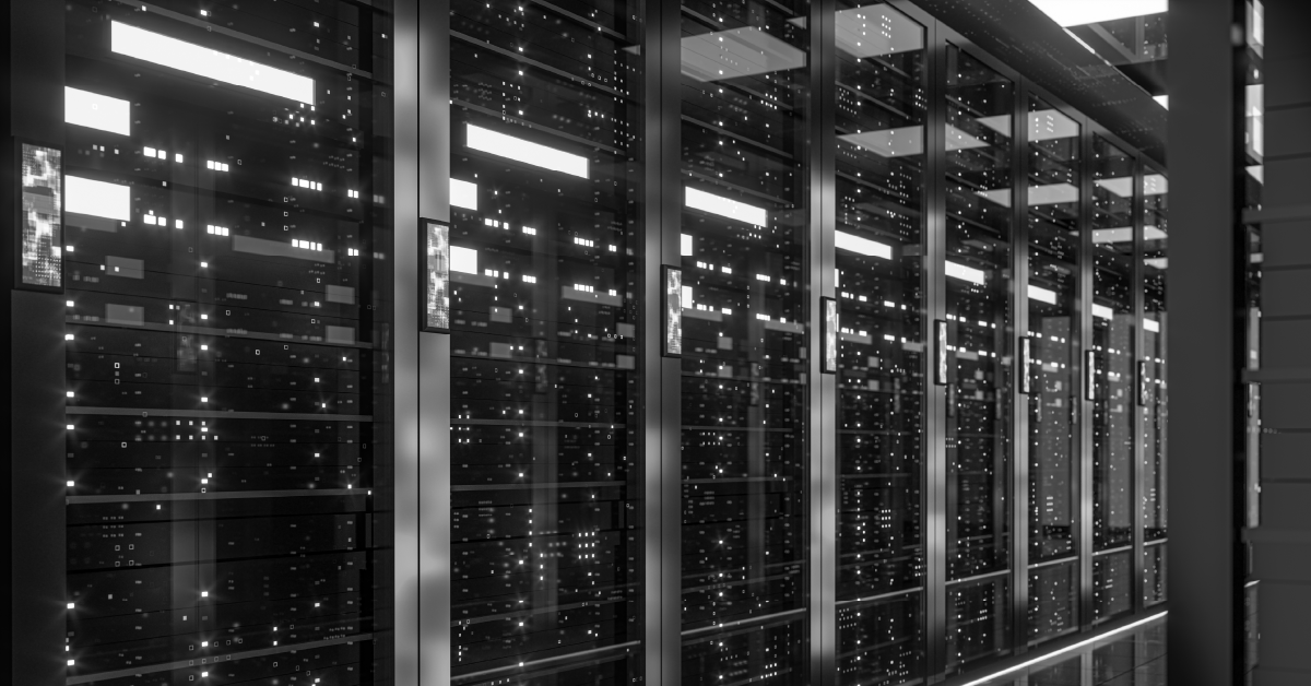 Corredor moderno de data center em tons de cinza, com fileiras de racks de servidores e seus LEDs.